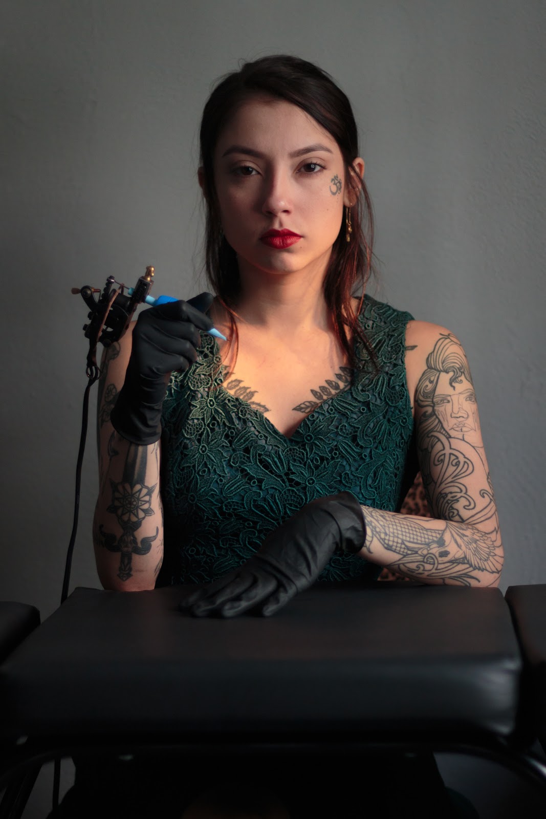 cómo convertirse en un tatuador: mujer tatuadora sosteniendo una pistola de tatuaje