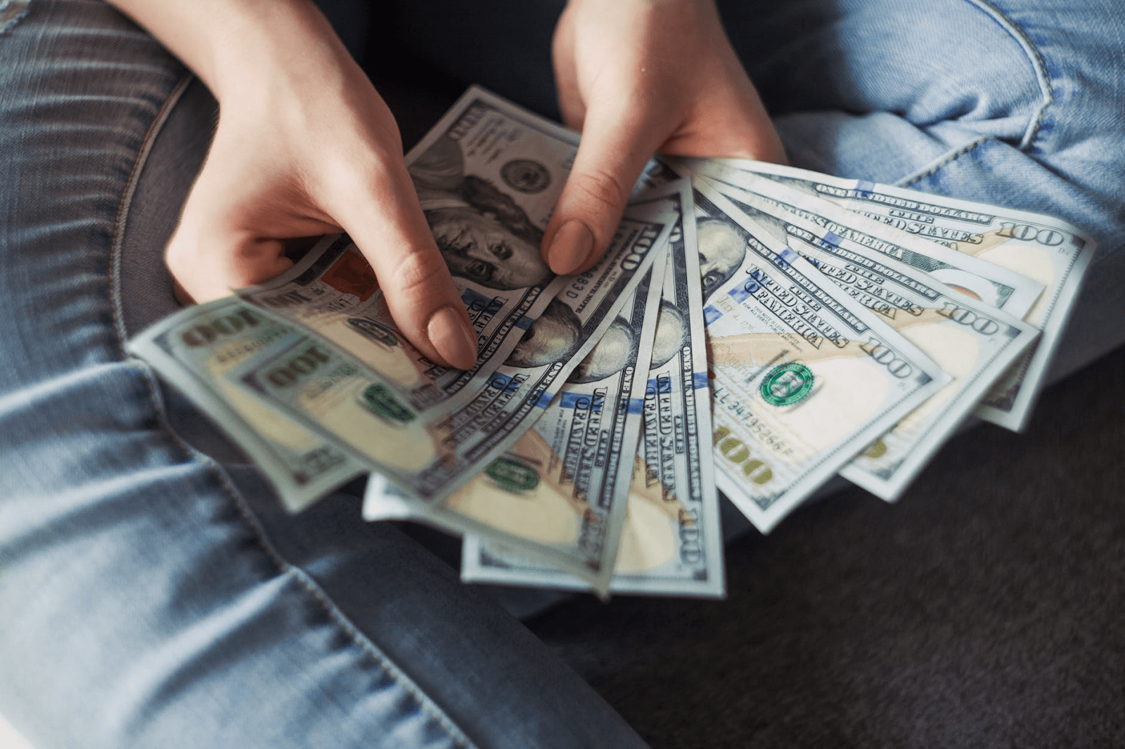 Amortización de préstamo: una mujer tiene billetes de cien dólares