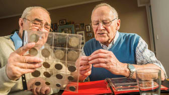 imagen de dos ancianos mirando una colección de monedas