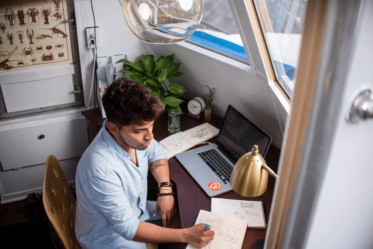 Trabajos que pagan bien: un hombre escribe en el escritorio de su oficina en casa