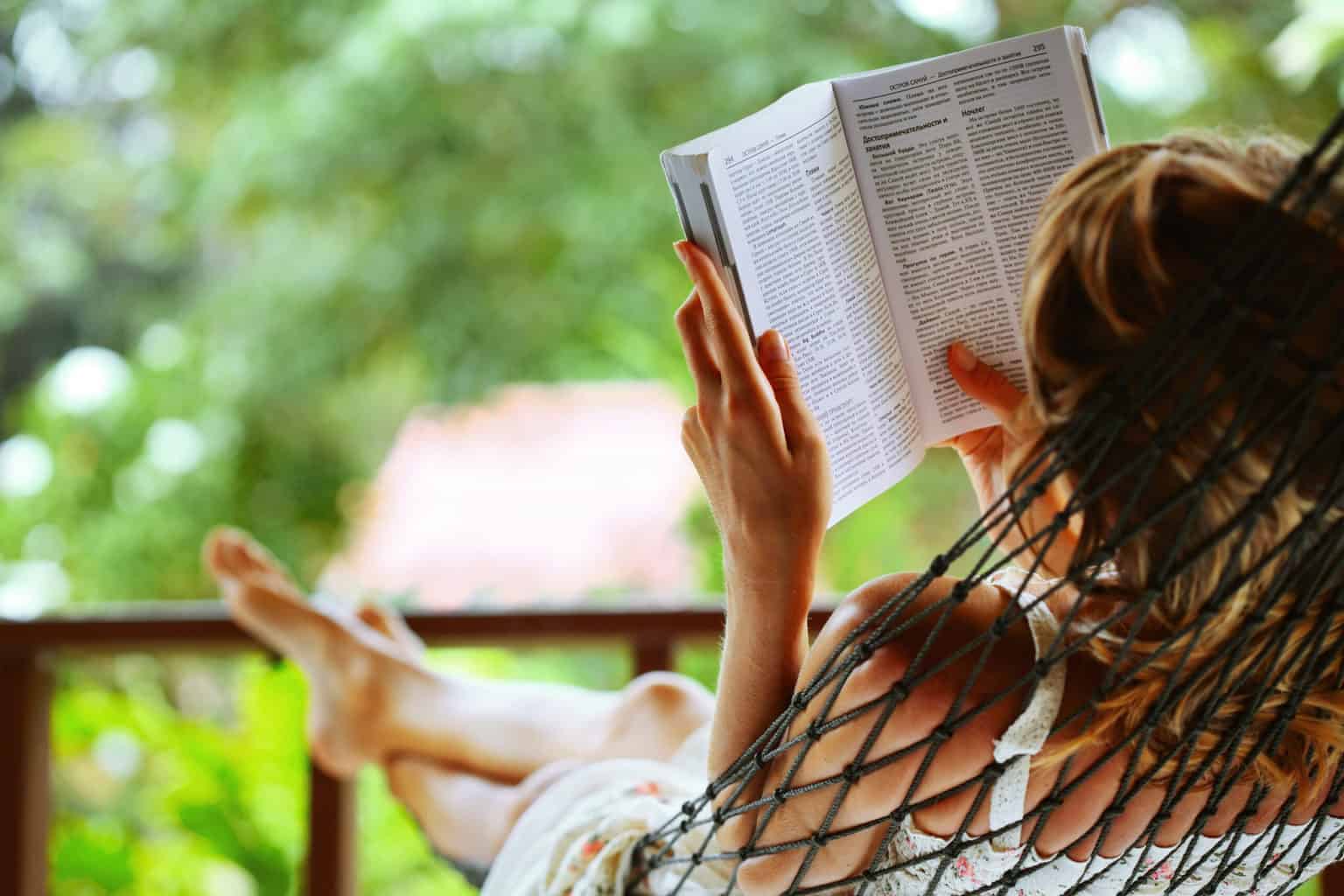 mujer leyendo libro en hamaca